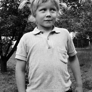 Young child outdoors in casual polo shirt.
