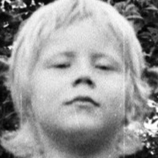 Young boy standing outdoors in casual clothes.