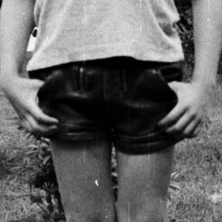 Young boy standing outdoors in casual clothes.