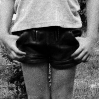 Young child standing outdoors in casual clothes.