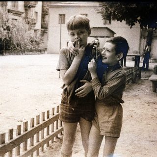 Two boys playing with toy guns outdoors.