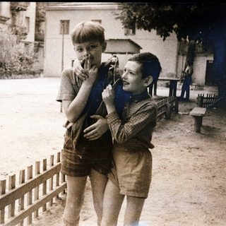 Two boys playing with toy guns outdoors.