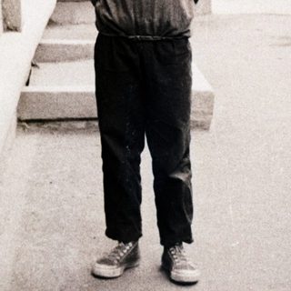 Young boy standing outdoors near brick building.
