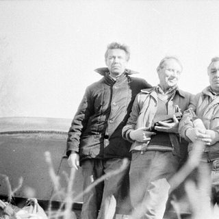 Three men posing outdoors in vintage clothing.
