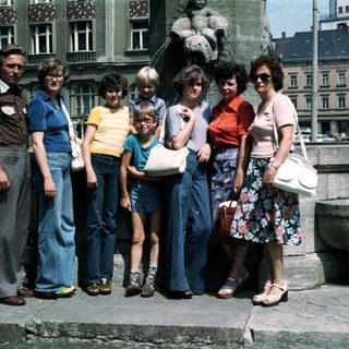 Family group photo in outdoor plaza, 1980s.