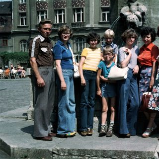 Family group photo in outdoor plaza, 1980s.