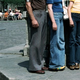 Family group photo in outdoor plaza, 1980s.