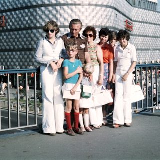 Group of people posing outdoors near modern building.