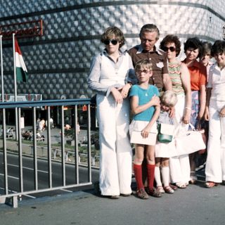 Group of people posing outdoors near modern building.