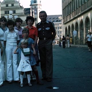 Family group photo in urban street setting, mid-1970s.