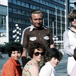 Group photo of adults and children outdoors in 1970s style clothing.