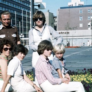 Group photo of adults and children outdoors in 1970s style clothing.