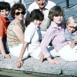 Family group photo in 1980s outdoor setting.