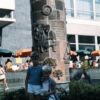 Two children posing near a historic monument.