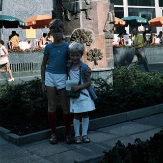 Two children posing near a historic monument.