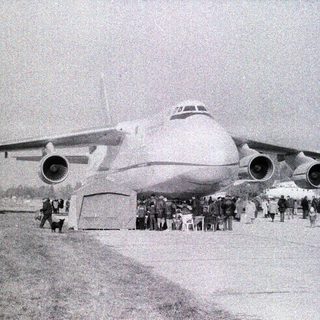 Large four-engine aircraft with crowd observing.