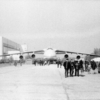 Large propeller aircraft with crowd observing.