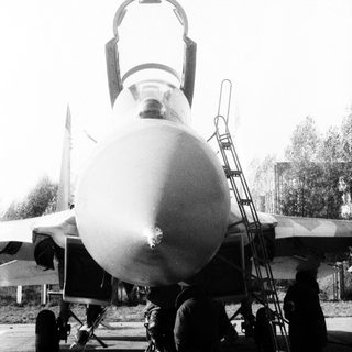 Military jet aircraft on display with open cockpit.