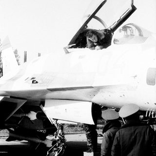 Jet fighter cockpit open, pilot inside, outdoor display.
