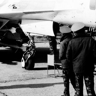 Jet fighter cockpit open, pilot inside, outdoor display.