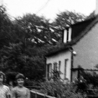 Two individuals walking on a paved path beside a construction area.