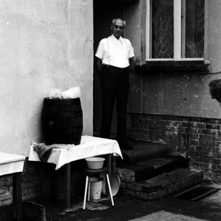 Man standing outside near laundry and household items.