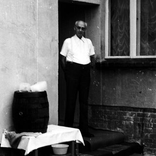 Man standing outside near laundry and household items.