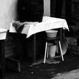 Man standing outside near laundry and household items.