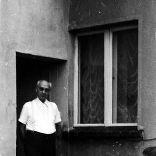 Man standing outside near laundry and household items.