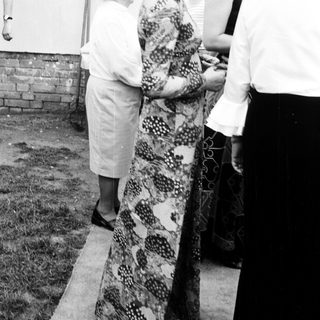 Four women standing outdoors near a fence.