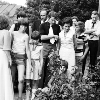 Group of people gathered outdoors in 1970s attire.