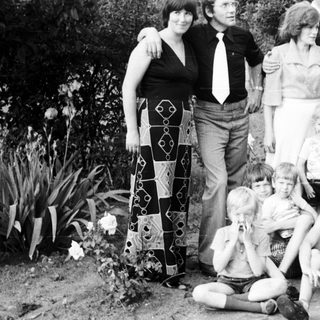 Family group photo outdoors in the 1970s–1980s.