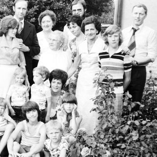 Family group photo outdoors in the 1970s–1980s.