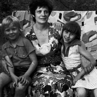 Family portrait with three people outdoors in 1970s-style clothing.