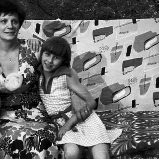Family portrait with three people outdoors in 1970s-style clothing.