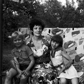 Family portrait with three people outdoors in 1970s-style clothing.
