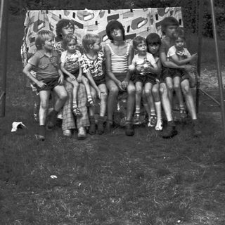 Group of children posing together outdoors in 1960s-style clothing.