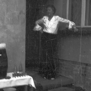 Blurred reflection of person playing piano indoors.