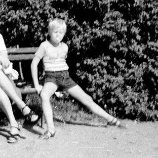 Three children sitting on a bench outdoors.