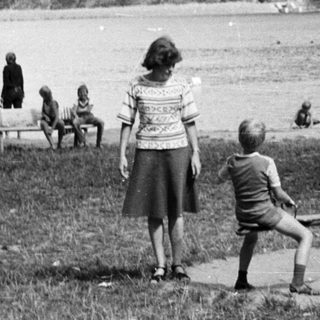 People enjoying lakeside picnic by water.