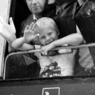 Family waving from a train window.