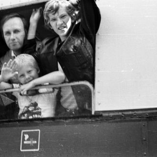 Family waving from a train window.