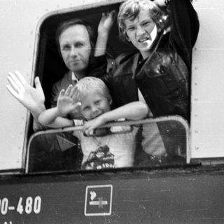 Family waving from a train window.