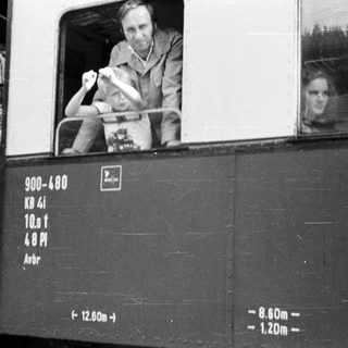 Man waving from old train carriage door.