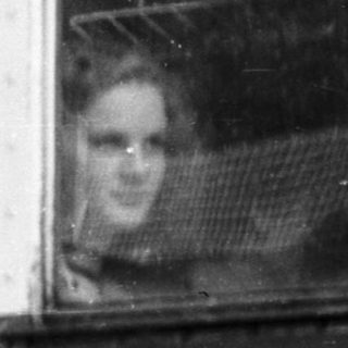 Man waving from old train carriage door.