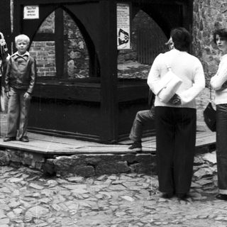 Timeless photo of people near Tudor-style half-timbered building.