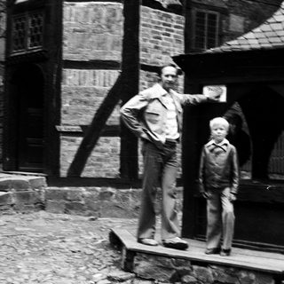 Two men standing outside an old building.