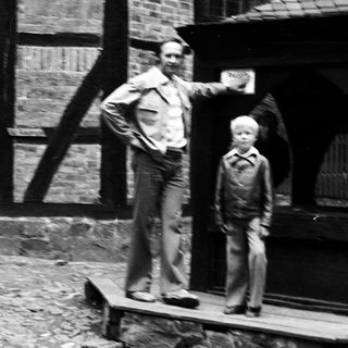Two men standing outside an old building.