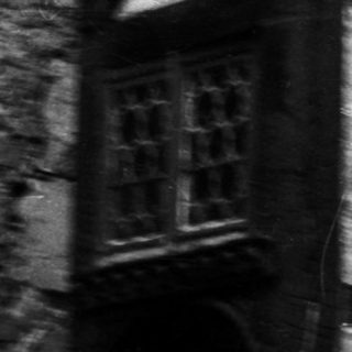 Two men standing outside an old building.