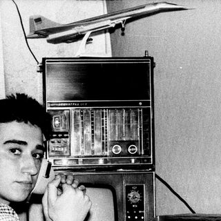 Young man using vintage radio with headphones.